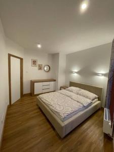 a bedroom with a bed and a wooden floor at Zacisze apartament in Zielona Góra