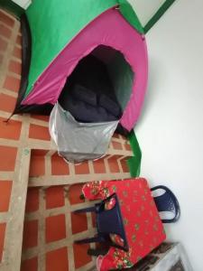 a table with a umbrella and a cell phone at Camping el triunfo in Montecillo