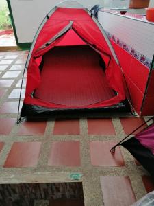 una tienda roja sentada en un suelo de ladrillo en Camping el triunfo, en Montecillo