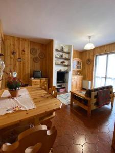 a living room with a wooden table and chairs at Appartamento Cerreto Laghi in Cerreto Laghi
