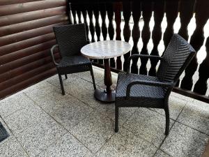 twee stoelen en een tafel op een patio bij G122 SREČNA HIŠKA Aqualuna & Terme Olimia Vstopnice in Podčetrtek