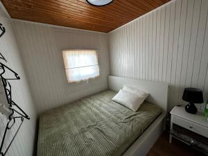 een klein bed in een kleine kamer met een raam bij G122 SREČNA HIŠKA Aqualuna & Terme Olimia Vstopnice in Podčetrtek