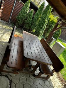 einem Picknicktisch aus Holz und einer Bank auf einer Terrasse in der Unterkunft SREČNA HIŠKA Aqualuna & Terme Olimia G122 in Podčetrtek