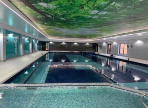 a swimming pool with a ceiling with a tree on it at 81 Hengar Manor in Bodmin