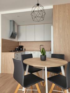 a kitchen with a wooden table and chairs at Apartament Korczaka 6 in Śrem