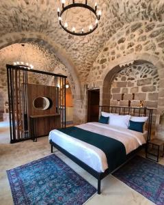 um quarto com uma cama grande e uma parede de pedra em TUĞMANER Small House AJAR em Mardin