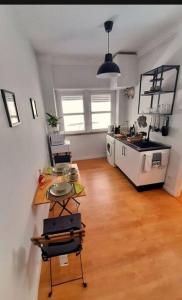 a kitchen with a table and a counter in a room at Conforto e Bem estar in Lisbon