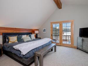 una camera da letto con un letto grande e una televisione di Powder Ridge Cabin 6 Rose Bud a Big Sky