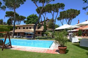 a swimming pool in front of a house with trees at Parco delle Nazioni - Relax Grand Resort in Castel di Decima