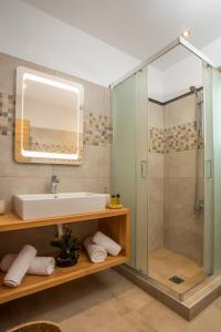 a bathroom with a sink and a shower at M&E APARTMENTS in Haraki