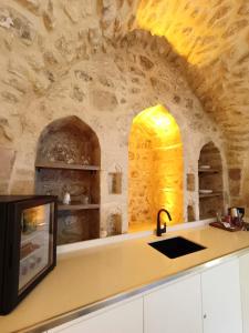 a kitchen with a counter with a sink and an oven at TUĞMANER Small House AJAR in Mardin