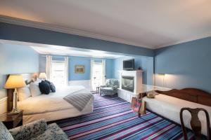 a hotel room with two beds and a fireplace at Kennebunkport Inn in Kennebunkport