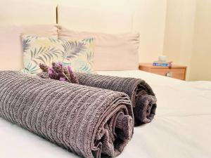 a bed with two knitted blankets on top of it at Elegant modern loft in Kryopigi in Kriopigi +2 photos
