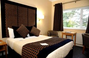 a hotel room with a large bed and a window at Carlton Park Hotel Rotherham in Rotherham