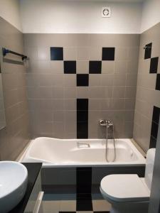 een badkamer met een bad, een toilet en een wastafel bij Modern & Comfortable, Single Floor Apartment***** in Heraklion