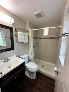 a bathroom with a toilet and a sink and a shower at Bestway Inn in Muncie