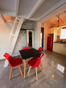 a dining room with a black table and red chairs at Nikoli House in Vaia