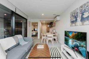 a living room with a couch and a tv at 1Br Braddon retreat with mountain views in Canberra