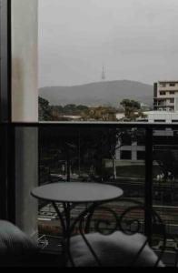 balcón con mesa y vistas a la ciudad en Mountain views at Midnight in the heart of Canberra, en Canberra