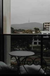 a balcony with a table and a view of a city at 1Br Braddon retreat with mountain views in Canberra
