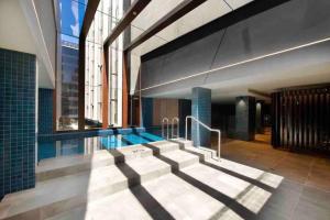 a swimming pool in a building with a large window at 1Br Braddon retreat with mountain views in Canberra