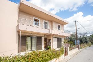 a white house with a balcony on a street at M&E APARTMENTS in Haraki