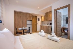 a bedroom with a bed with two white towels on it at M&E APARTMENTS in Haraki