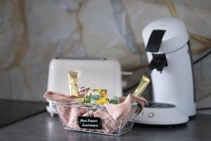 a basket of food sitting on a counter next to a toaster at Cottage Au Coin du Feu in Rambouillet