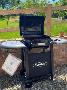 a grill with a laptop on top of it at The Hayloft, Pillar Box Farm Cottages in Ludlow