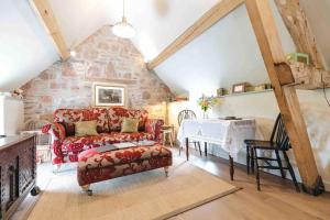 a living room with a red couch and a table at The Hayloft, Pillar Box Farm Cottages in Ludlow