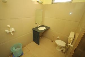 a bathroom with a toilet and a sink and a mirror at Hotel Mukund Priya- Near Krishna Janam Bhoomi in Mathura