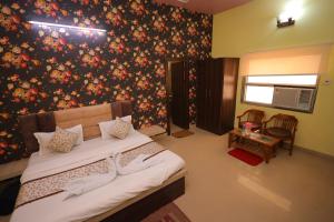 um quarto com uma cama com uma parede floral em Hotel Mukund Priya- Near Krishna Janam Bhoomi em Mathura