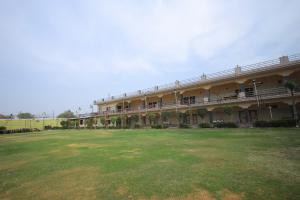 a large building with a large yard in front of it at Hotel Mukund Priya- Near Krishna Janam Bhoomi in Mathura