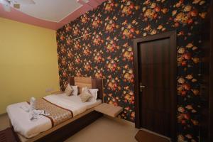a bedroom with a bed with a floral wallpaper at Hotel Mukund Priya- Near Krishna Janam Bhoomi in Mathura