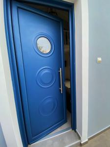 Nikoli House في Vaia: الباب الأزرق مع نافذة مستديرة عليه