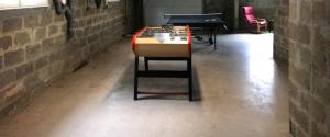 a ping pong table in a brick room with a ping pong table at GITE Thiron Gardais LA COUR aux PAUVRES in Thiron-Gardais