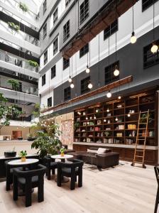 a library with tables and benches in a building at The Metcalfe by Gray Collection in Ottawa