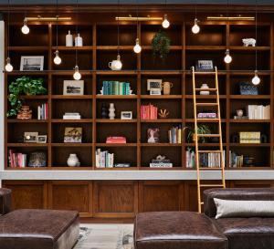 a library with wooden bookshelves and brown furniture at Metcalfe Hotel Ottawa by Gray Collection in Ottawa