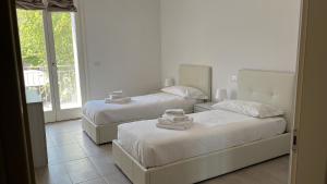 um quarto com 2 camas e uma janela em Castramajora Alloggi em Casalmaggiore