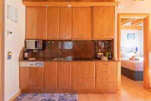 uma cozinha com armários de madeira e um micro-ondas em Apartamento con Encanto em Vielha