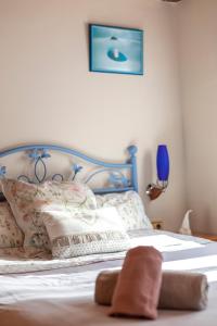a bed with a blue headboard and pillows on it at Apartamento con Encanto in Vielha