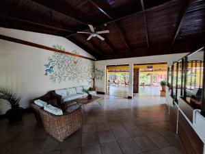- un salon avec un canapé et un ventilateur de plafond dans l'établissement Hotel Las Espuelas, Bar & Restaurant, à Liberia