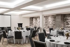 une salle de conférence avec des tables et des chaises ainsi qu'un podium dans l'établissement The Metcalfe by Gray Collection, à Ottawa