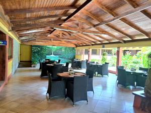 un ristorante con soffitti e tavoli in legno e sedie di Hotel Las Espuelas, Bar & Restaurant a Liberia