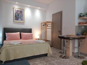Un dormitorio con una cama, una mesa y un escritorio. en Nisos suite, en Ermoupoli