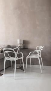 2 sillas blancas y una mesa en una habitación en Baltic Room en Sopot