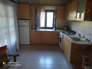 a kitchen with a sink and a stove top oven at katerina house in Ormos Panagias
