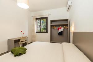 a bedroom with a bed and a desk and a window at Il Rifugio in Baunei