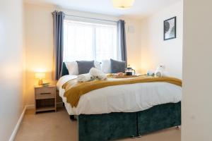 a bedroom with a bed with two stuffed animals on it at Stylish 2 bedroom, 2 bathroom with Sky TV, Free Parking and WiFi By HP Accommodation in Milton Keynes