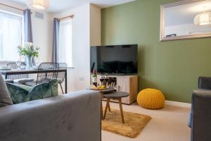 a living room with a couch and a tv at Stylish 2 bedroom, 2 bathroom with Sky TV, Free Parking and WiFi By HP Accommodation in Milton Keynes